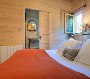 Les Cabanes dans les Bois (près de Carcassonne) - Grand lit et salle d'eau ©Florent Chatroussat
